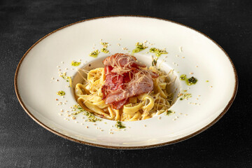 Pasta in a white plate on a black background