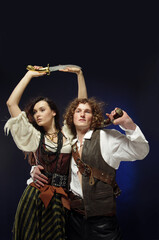 A guy and a girl in pirate costumes.