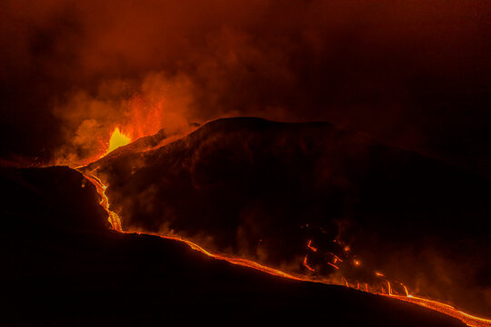 Aerial top down view of lava floating down the Volcan Cumbre Vieja at night, a volcano during eruption near El Paraiso town, Las Manchas, La Palma Island, Canary Islands, Spain.