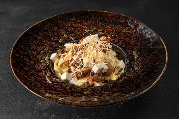 Pasta in a black plate on a black background