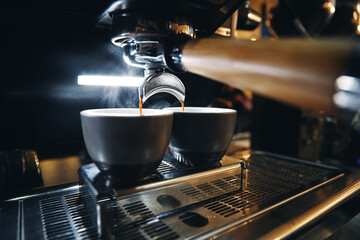 Close up photo of espresso machine working with bar interior background