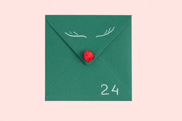 Concept of congratulation for Christmas, New Year. Green envelope isolated on rose background....