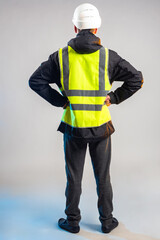 Man in reflective vest. Worker with his back to camera. Man in vest and camera turned away. Worker...