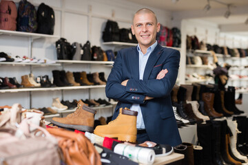Portrait of positive male shoe seller in a shoe store