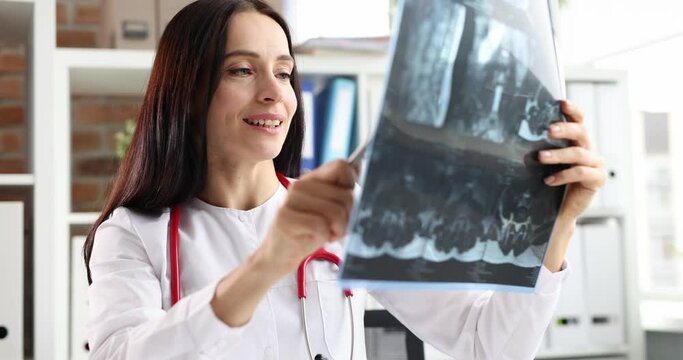 Female doctor examines x-ray slow motion 4k movie