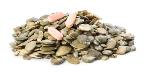 Pumpkin seeds and pills on white background