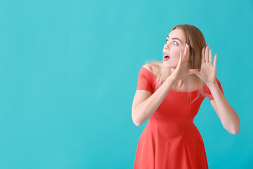 Curious young woman trying to hear something on color background