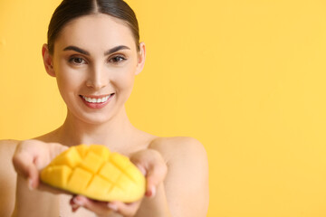 Beautiful smiling woman with cut mango on color background