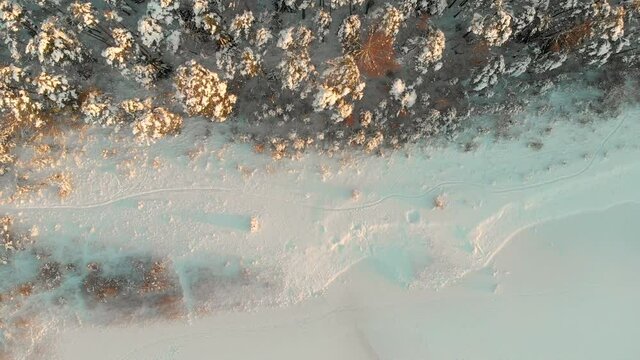 Beautiful aerial rotating top-down view of snow covered forests aroung Gela lake