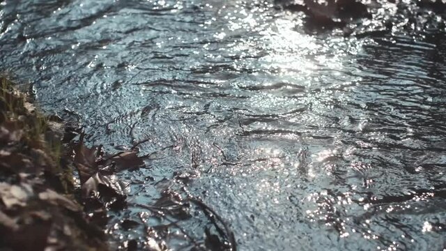 slow motion of a little river in mountain with flare