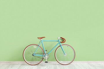 Stylish bicycle near green wall
