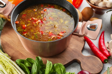 Cooking pot with delicious soup on table