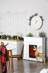 Interior of modern kitchen with Christmas decor on counter and mantelpiece