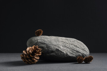 Black stone and cones podium display, background for autumn or winter products, jewellery, food and cosmetics. Mockup.	