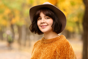 Portrait of fashionable woman wearing felt hat in autumn park