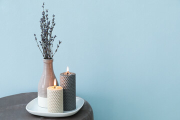 Composition with glowing candles on pouf in room