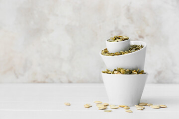 Bowls with pumpkin seeds on table © Pixel-Shot