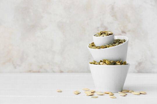 Bowls with pumpkin seeds on table