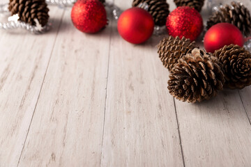 Pine cones and red christmas balls for christmas decoration on rustic white wooden background. Copy space for your text