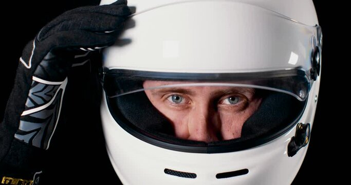 Man with strong blue eyes looking into the camera and closing the helmet visor in 4k slow motion