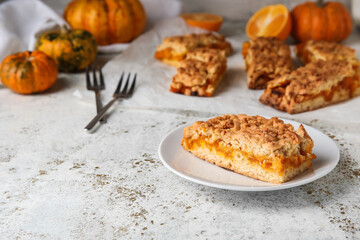 Plate with piece of fresh pumpkin pie on light background