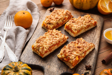 Board with pieces of tasty pumpkin pie on wooden background