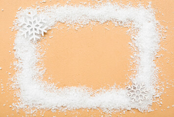 Fototapeta na wymiar Frame made of snow and snowflakes on color background