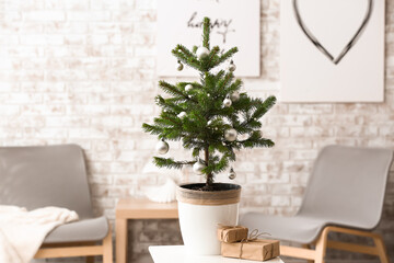 Beautiful decorated Christmas tree and gift boxes on table in room