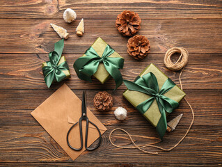 Composition with Christmas gifts, envelope and pine cones on wooden background
