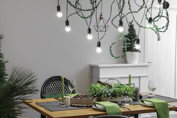 Dining table with beautiful setting for Christmas celebration in festive room