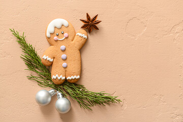 Composition with tasty gingerbread man, coniferous branches and Christmas balls on color background
