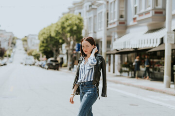 Obraz premium Casual woman crossing the street in downtown, San Francisco