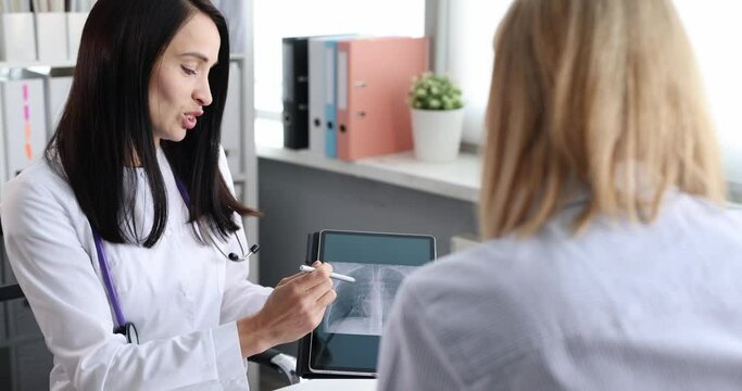 Woman doctor showing xray of lungs on digital tablet to patient 4k movie slow motion