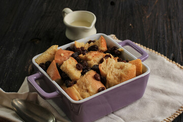 Close Up Cinnamon Bread and Butter Pudding with Raisins in Clear Baking Dish, Served with Vla
