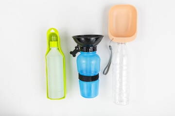 Set of bottles for dogs to drink water outside on white background. Multicolored bottles from plastic with different shapes for drinking. Dogs care and accessory