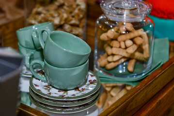 Breakfast table, tray with decorated cookie jar, blue cups and saucer