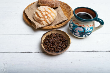 traditional cup of Mexican coffee, roasted coffee beans and sweet bread conchas
