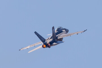 Tail view of a F-18 Hornet in a high G maneuver, with condensation streaks at the wing roots and...
