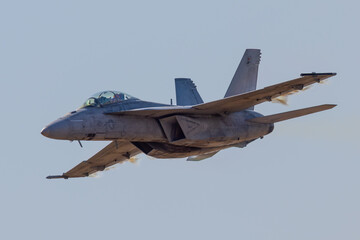 Very close view of a F-18 Hornet approaching in a high G maneuver, with condensation cloud around the plane