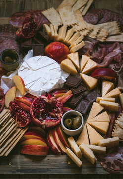 Winter Charcuterie Board with Cheeses, Meat, Chocolate, and Pomegranate