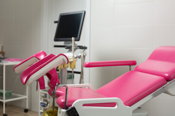 Photo of a pink gynecological chair in an equipped office of a modern medical clinic