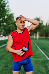 Fototapeta premium Cheerful sporty man in the park on green grass doing exercises
