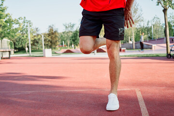 Muscled athletic men on the sports ground workout exercises