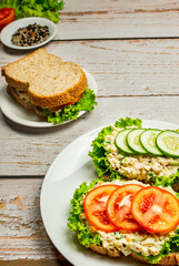 Homemade egg salad sandwich with wholewheat bun,cucumber, tomatoes,lettuce,egg,and cream cheese.  Rustic style. Selective Focus. Top view. Copy space. No.06