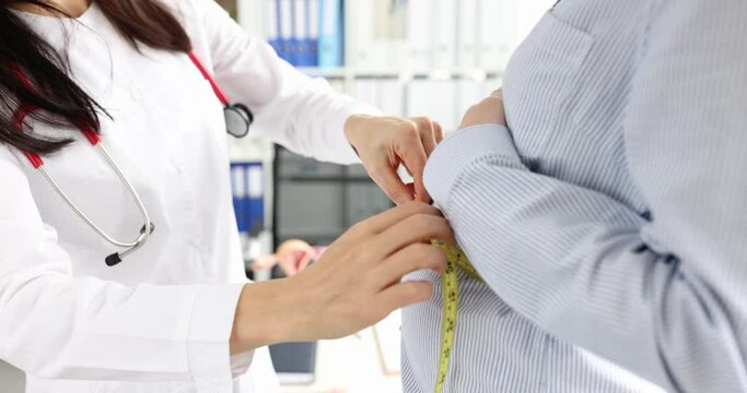 Gynecologist measuring waist circumference of pregnant woman patient in clinic 4k movie slow motion
