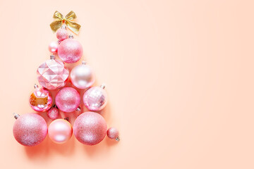 Innovative Christmas tree made of Christmas ornaments on pink background