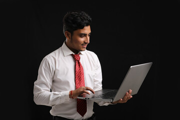 Young indian banker or officer using laptop