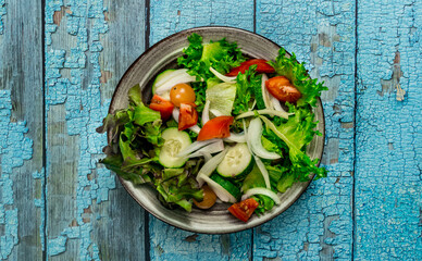 Vegetable salad. The best salad ingredients for weight loss with fresh lettuce, tomatoes and cucumber,olive oil in ceramic bowl. Top view. Copy space. No.04