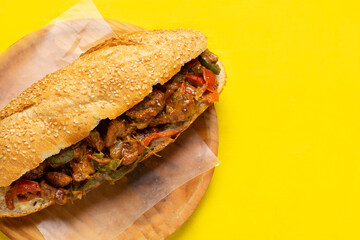 Philly cheese steak with bell pepper on yellow background