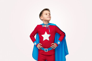 Brave superhero boy in costume in studio
